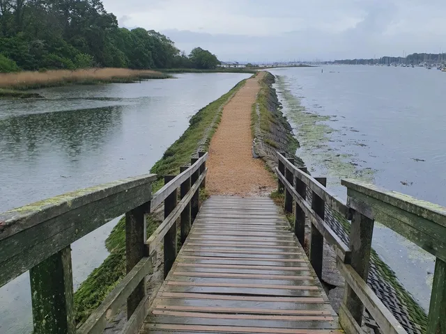 Gravel footpath along the River Hamble near Warsash with yachts moored on the water